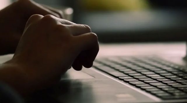 Closeup hands typing on laptop keyboard
