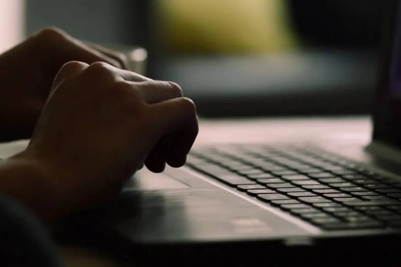 Close up image of a hand typing on a laptop
